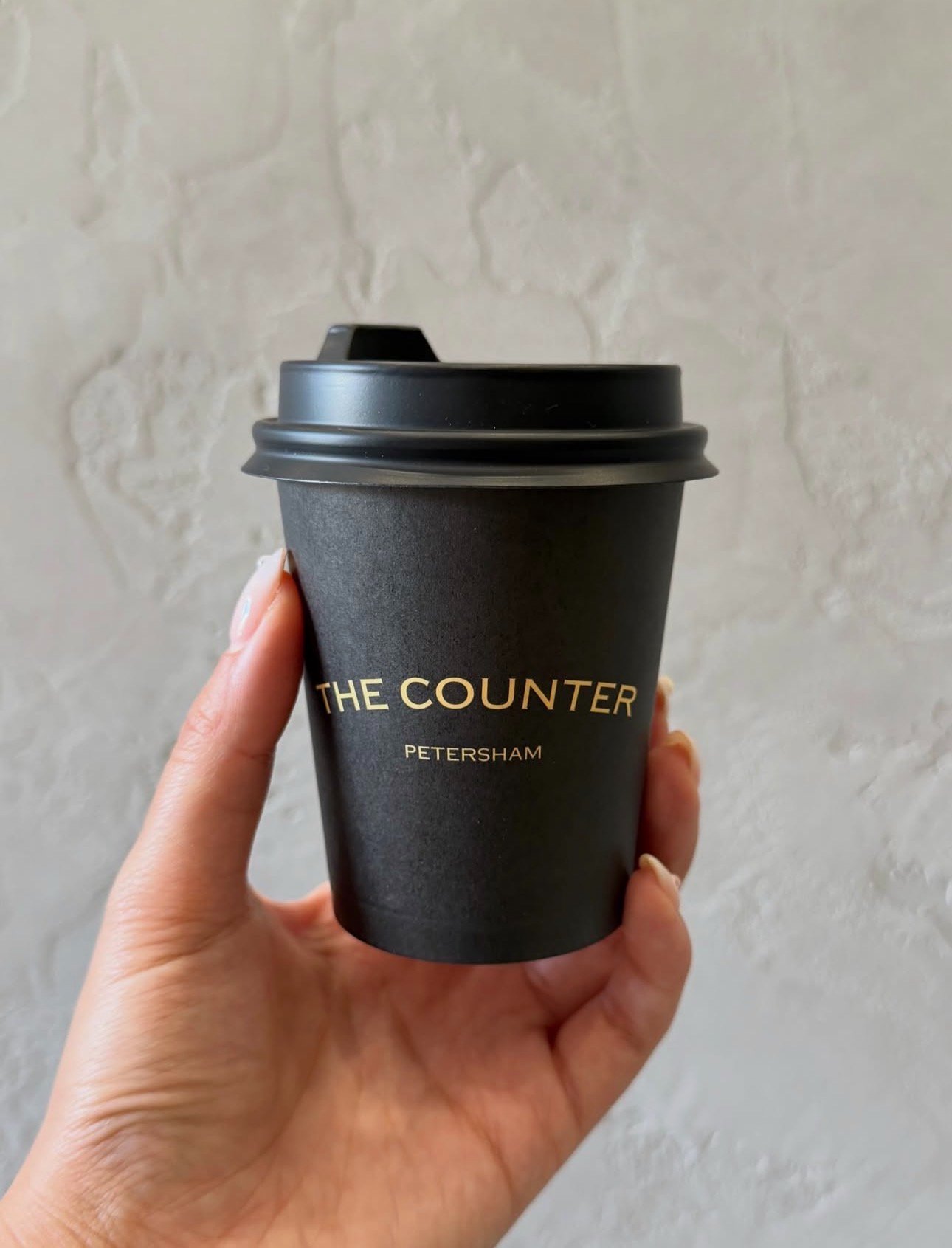 The Counter Petersham black takeaway cup with gold logo